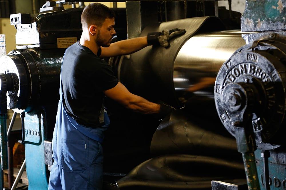 man working with rubber in factory